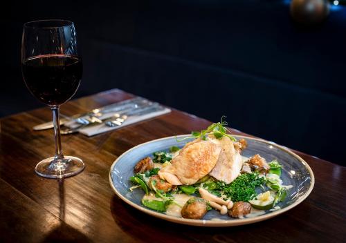 a plate of food on a table next to a glass of wine at Kingscliff, BW Signature Collection in Clacton-on-Sea