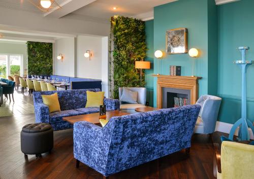 a living room with blue furniture and a fireplace at Kingscliff, BW Signature Collection in Clacton-on-Sea