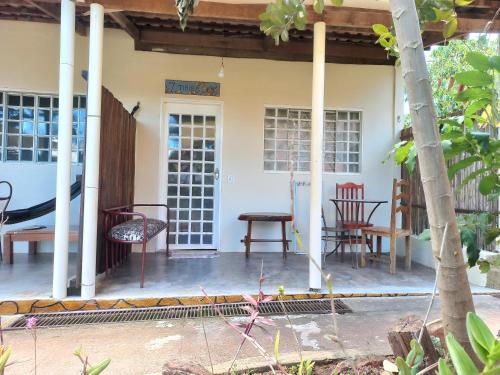 a porch of a house with chairs and a table at Pousada Veadeiros - Alto Paraiso de Goiás in Alto Paraíso de Goiás