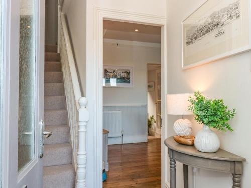 a hallway of a home with a staircase and a table at Juniper Cottage in Dartmouth