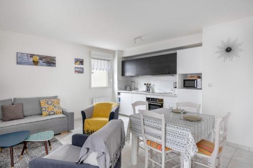 une cuisine et un salon avec une table et des chaises dans l'établissement Escapade en duo au coeur de Sarzeau, à Sarzeau