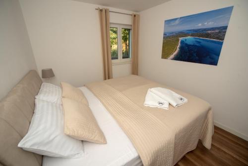 1 dormitorio con 1 cama con sábanas blancas y ventana en Villa Median, en Žman