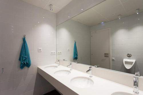 
a bathroom with two sinks and a mirror at Dream Cube Hostel in Barcelona
