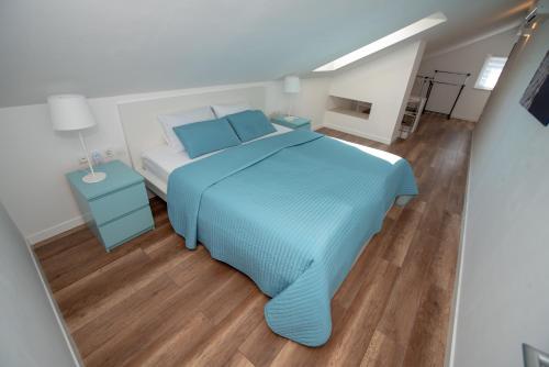 a bedroom with a blue bed and a wooden floor at Villa Median in Žman