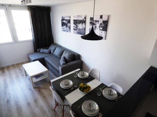ein Wohnzimmer mit einem Tisch und einem Sofa in der Unterkunft Plac Grzybowski Apartment in Warschau