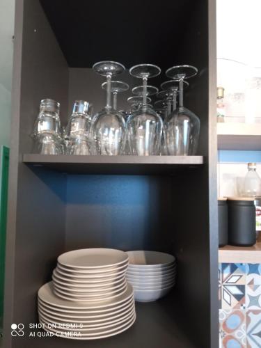 a shelf with plates and glass jars on it at Abaton - Casa vacanza in Metaponto