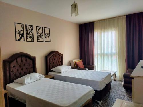 Habitación de hotel con 2 camas y ventana en The Tuyap Rainbow Suites, en Beylikduzu