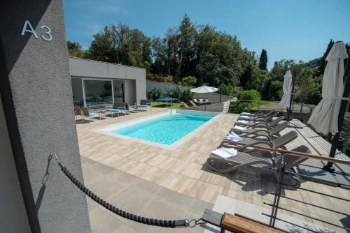 a swimming pool with lounge chairs next to a building at Villa Median in Žman
