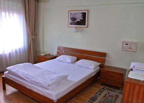 ein Schlafzimmer mit einem großen Bett mit weißer Bettwäsche in der Unterkunft ViP Apartments in Çekirge