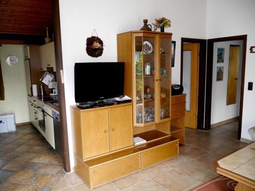 ein Wohnzimmer mit einem Flachbild-TV und eine Küche in der Unterkunft Bungalow M 43 in Burhave in Burhave