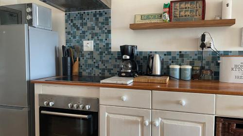 a kitchen with a counter top with a coffee maker at Victorian Beach Cottages in Amanzimtoti