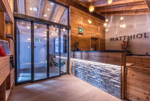a bar in a restaurant with a stone wall at Matthiol Boutique Hotel in Zermatt