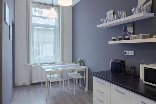 uma cozinha com mesa e cadeiras e uma janela em HEMNES Apartman em Kaposvár