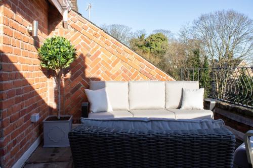 un canapé blanc assis sur un mur de briques dans l'établissement Tiger Roof Terrace Lymm, à Lymm