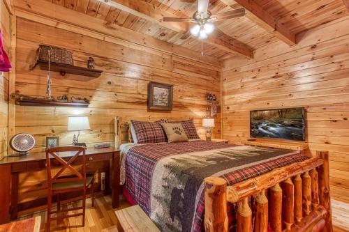 a bedroom with a bed and a desk in a cabin at Highland Dream, Hot Tub, FREE tickets each paid day, Near Dollywood, WIFI!!! in Sevierville