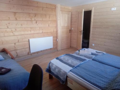 um quarto com uma cama e uma televisão de ecrã plano em Miodowa Chata Pokoje Gościnne em Bustryk