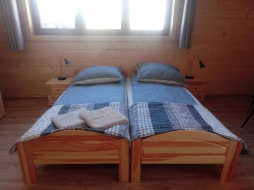 two beds in a room with two towels at Miodowa Chata Pokoje Gościnne in Bustryk