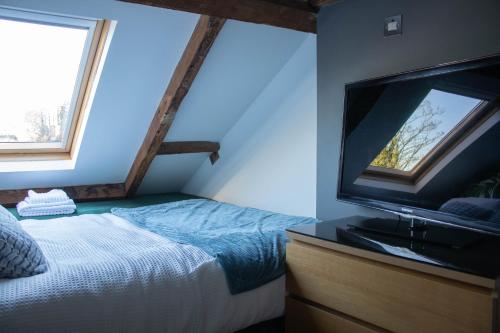 um quarto com uma cama e uma televisão de ecrã plano em Tiger Roof Terrace Lymm em Lymm