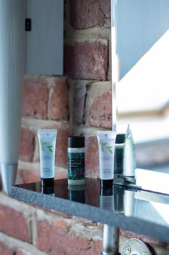 a shelf with three products on it in front of a mirror at Tiger Roof Terrace Lymm in Lymm