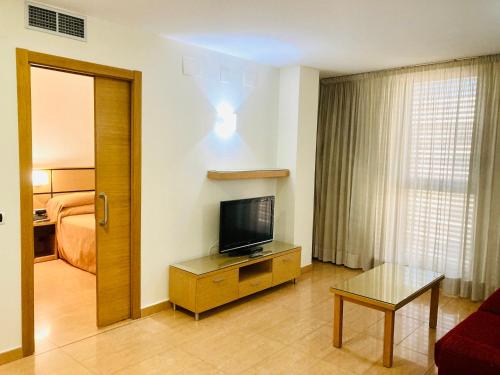 a hotel room with a television and a bed at Doña Lola in Castellón de la Plana