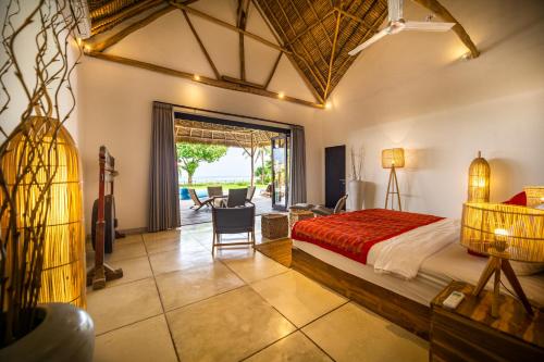 a bedroom with a bed and a living room at Villa Jac in Selong Belanak