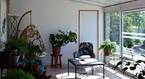 a room filled with lots of plants and a table at Bleu Outremer in Saint-Cast-le-Guildo