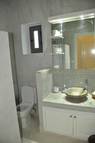 La salle de bains est pourvue d'un lavabo, de toilettes et d'un miroir. dans l'établissement VILLA KENZA, à Midoun