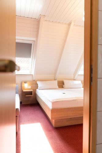 a bedroom with a bed and a window at Hotel-Restaurant Straussen in Harburg