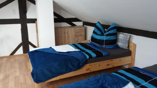 a bed with a blue and black comforter in a room at Fam.Singer in Garching an der Alz