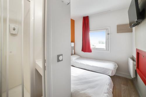 a small room with two beds and a window at Premiere Classe Valence - Bourg Les Valence in Bourg-lès-Valence