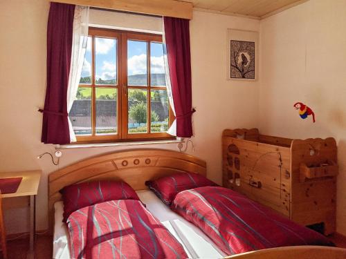 a bedroom with a bed with red pillows and a window at Familienferienwohnung Villa Zaunkönigin in Bischofsheim an der Rhön