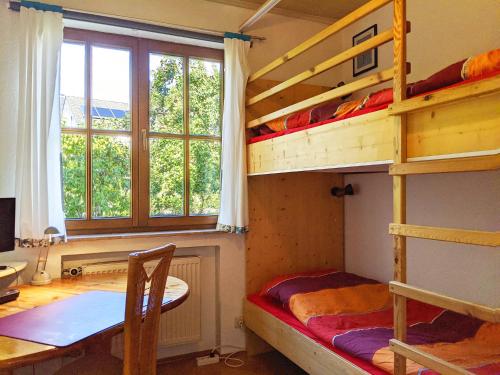 a bedroom with two bunk beds and a table at Familienferienwohnung Villa Zaunkönigin in Bischofsheim an der Rhön