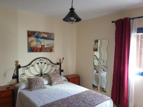 a bedroom with a bed and a painting on the wall at Apartamento Tabayba Arena in Punta de Mujeres