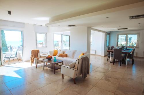 een woonkamer met een bank, stoelen en een tafel bij Amathus suite with sea view in Limassol