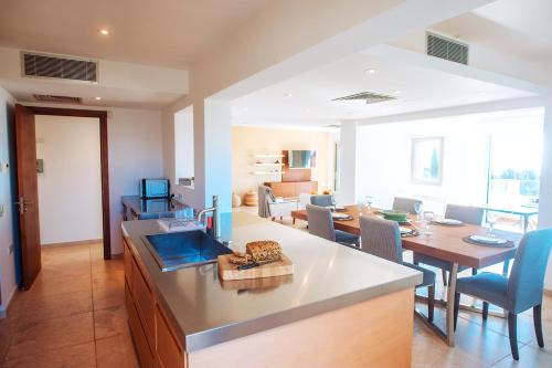 a kitchen and living room with a table and a dining room at Amathus suite with sea view in Limassol