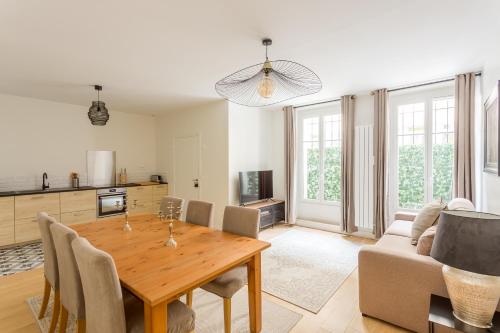 Il comprend un salon avec une table en bois et une cuisine. dans l'établissement Croissants et Confitures, à Paris