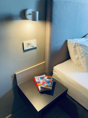 a table with a book on it next to a bed at Amaryllis in Plataniás