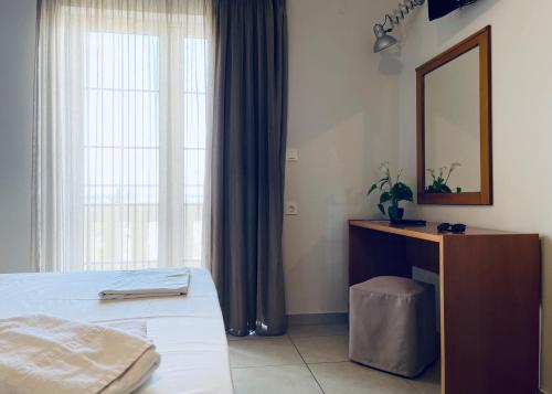 a bedroom with a bed and a dresser and a mirror at Amaryllis in Plataniás