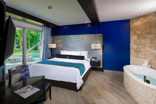 a hotel room with a large bed and a large window at Hard Rock Hotel Riviera Maya - Hacienda All Inclusive in Puerto Aventuras