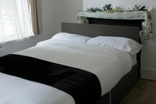 a bedroom with two beds with white pillows at cozy rooms in London Townhouse fast links to Central in London