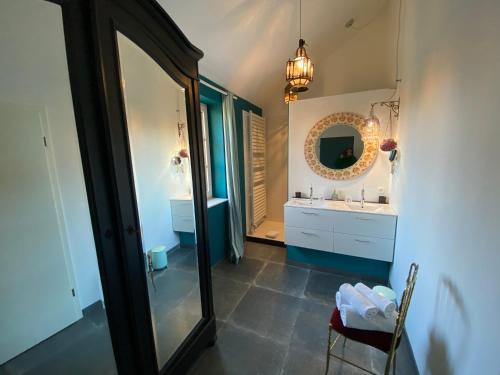 La salle de bains est pourvue d'un grand miroir et d'un lavabo. dans l'établissement Maison Jules, à Sainte-Ode