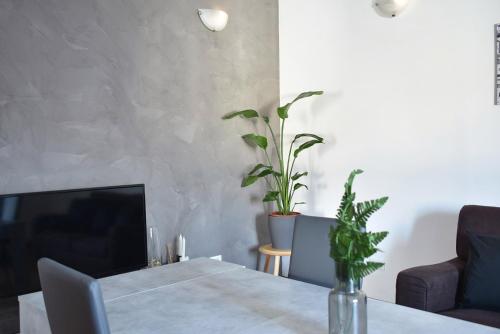 ein Wohnzimmer mit einem Tisch und einem TV in der Unterkunft By the Hills Apartment in Montegrotto Terme