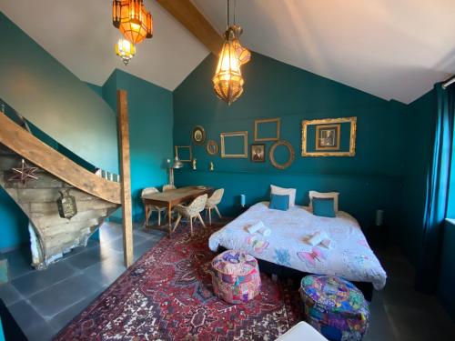 Schlafzimmer mit einem Bett und einem Tisch in der Unterkunft Maison Jules in Sainte-Ode