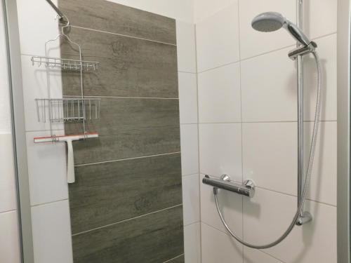 eine Dusche im Bad mit einer Holzwand in der Unterkunft Pension Likedeeler Doppelzimmer John Rackham in Borkum
