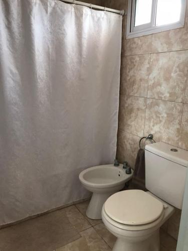 a bathroom with a toilet and a shower curtain at DEPARTAMENTO PARA DOS PERSONAS EN ZONA CENTRICA in Zárate