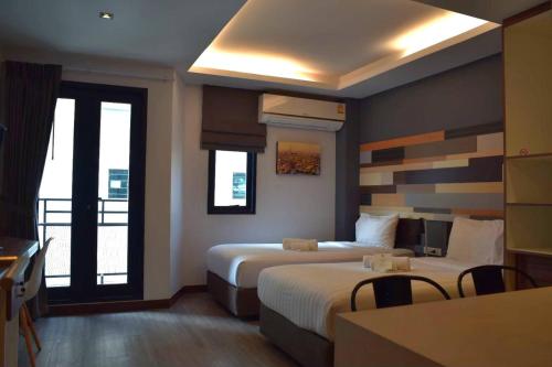 a hotel room with two beds and a kitchen at Campagne Hotel and Residence - SHA Plus in Pathum Thani