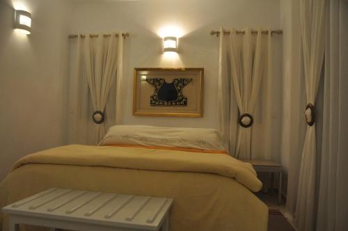 - une petite chambre avec un lit et un banc dans l'établissement VILLA KENZA, à Midoun