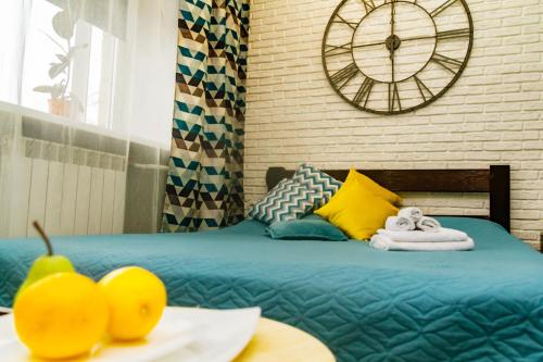 ein Schlafzimmer mit einem Bett mit einer Uhr an der Wand in der Unterkunft Weekend in Krasnojarsk