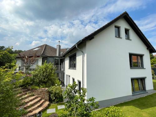 a white house with a black roof at Grüne Oase Am Mausauel in Nideggen