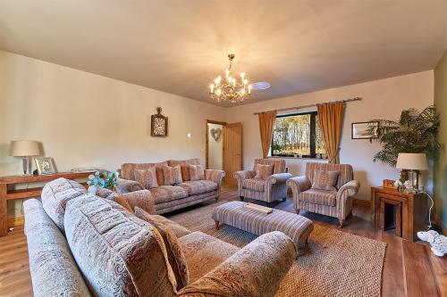 a living room with couches and chairs and a chandelier at Host & Stay - High Bellridge Farm in Kirkheaton